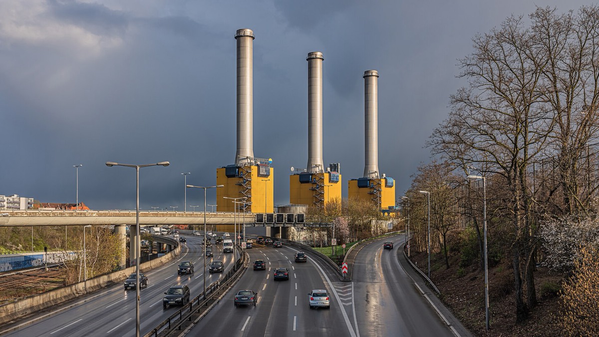 Three towers of a combined heat and power plant against a storm sky